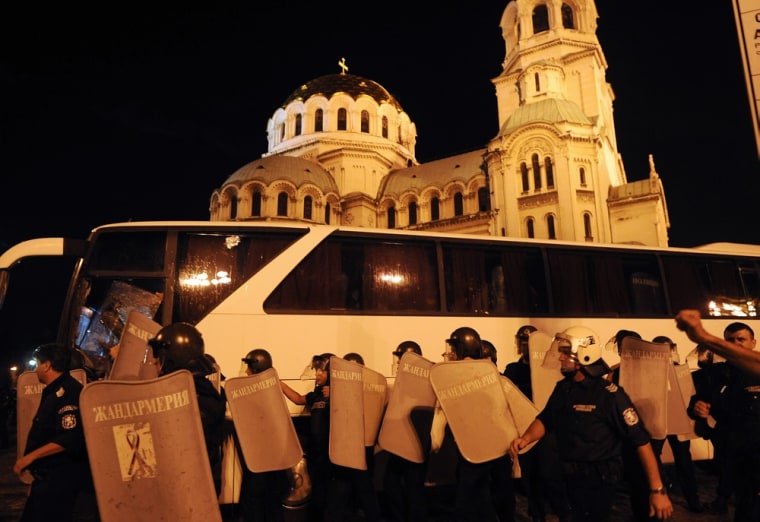 Riot policemen make way for lawmakers and parliament staff driven in a bus during an anti-government protest on July 23.