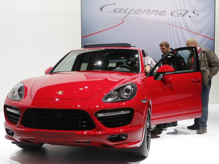 People watch a Porsche Cayenne GTS car during a press preview day at the AMI Auto Show in Leipzig June 1, 2012. The show opens to the public on June 2...