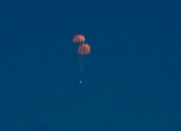 The Orion capsule falls to Earth with parachutes deployed at Yuma Proving Ground, Arizona, on July 24, 2013.