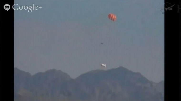 The Orion capsule falls closer to the ground with parachutes deployed at Yuma Proving Ground, Arizona, on July 24, 2013.