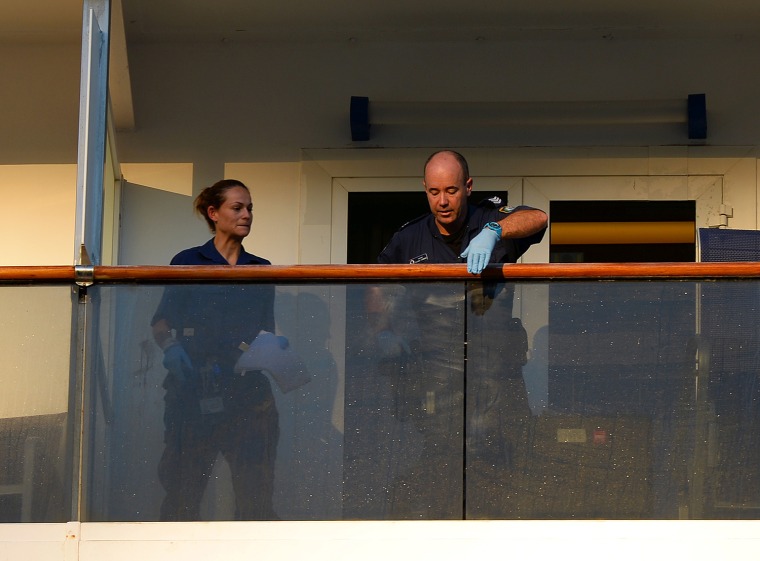 Two police officers check for fingerprints on the balcony of the cabin of two passengers who fell overboard from the cuise ship Carnival Spirit as it returned to Sydney from a Pacific cruise, on May 9, 2013.