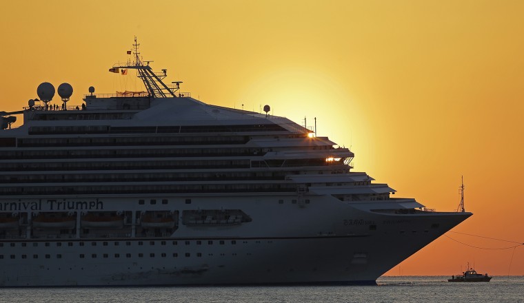 The cruise ship Carnival Triumph is towed into Mobile Bay near Dauphin Island, Ala., Thursday, Feb. 14, 2013. The ship with more than 4,200 passengers and crew members has been idled for nearly a week in the Gulf of Mexico following an engine room fire. (AP Photo/Dave Martin)