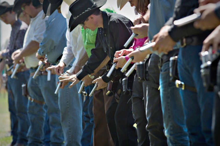 Competitors load their their guns with black powder blank cartridges while preparing to fire into the air and signal the start of the Canadian Open Fast Draw Championships in Aldergrove, British Columbia July 20, 2013.