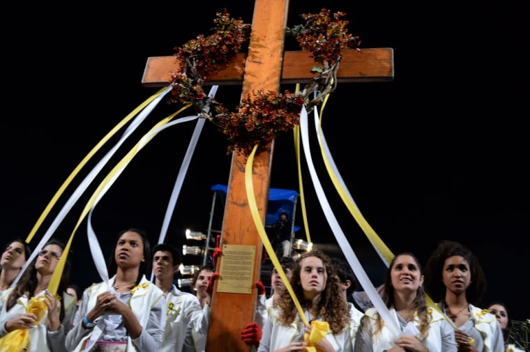 Youths take the cross during the re-enactment of the 14 Stations of the Cross -- scenes of Jesus carrying the cross to his crucifixion -- with the participation of Pope Francis, in Rio de Janeiro, on July 26.