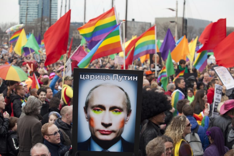 A demonstrator holds up a picture depicting Russian President Vladimir Putin with make-up during a protest by the gay community in Amsterdam on April 8, 2013.