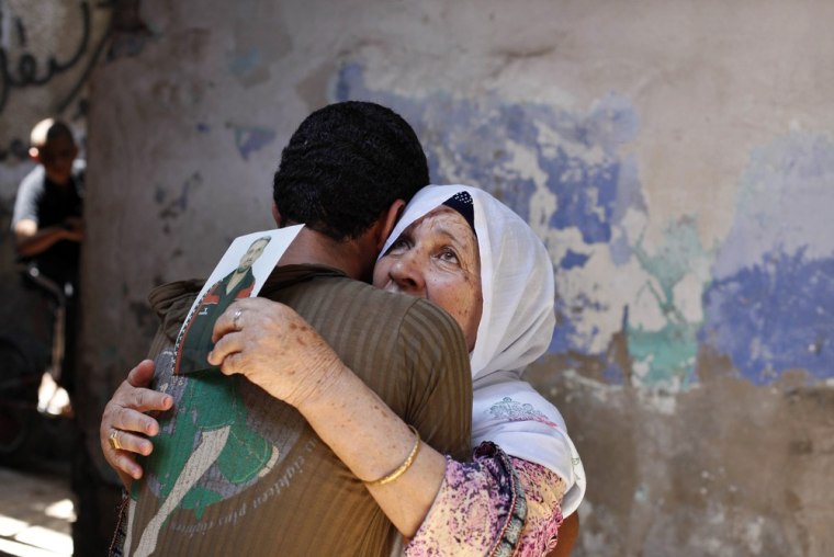 The mother of Palestinian Ateya Abu Moussa, who has been held prisoner by Israel for 20 years, reacts as she is hugged by her grandson after hearing news on the possible release of her son on July 28, 2013.