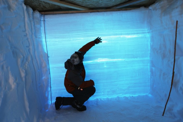 Professor David Noone from the University of Colorado uses a snow pit to study the layers of ice in the glacier at Summit Station on July 11 on the Glacial Ice Sheet, Greenland.