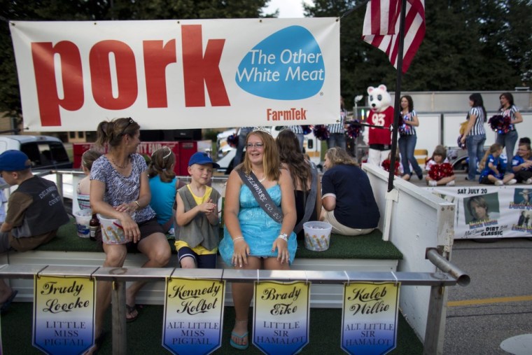 Leah Willie, center, 17, who was crowned Delaware County Pork Queen, sits in a parade float advertising pork products during the Delaware County Fair's kick-off parade in Manchester on July 8.