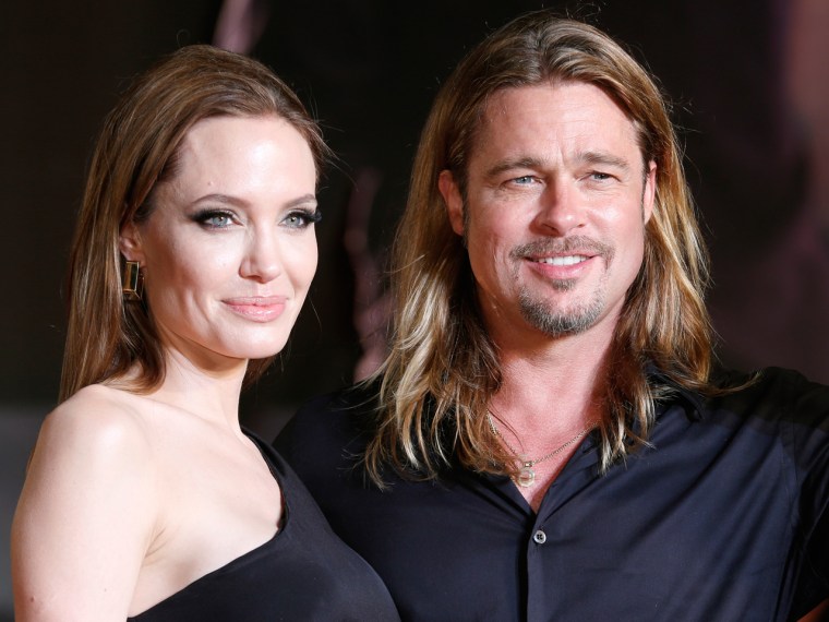 Brad Pitt, right, with Angelina Jolie poses for photographers during the Japan premiere of his latest film "World War Z" in Tokyo, Monday, July 29, 20...