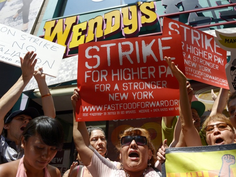 epa03806747 People gather outside of a Wendy's restaurant as part of a one day strike calling for higher wages for fast food workers in New York, New ...