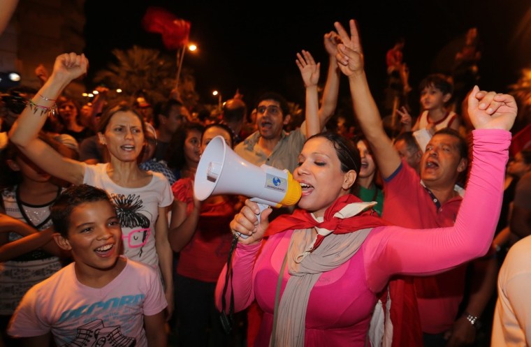 Tunisians protest near the parliament building in Tunis, Monday.