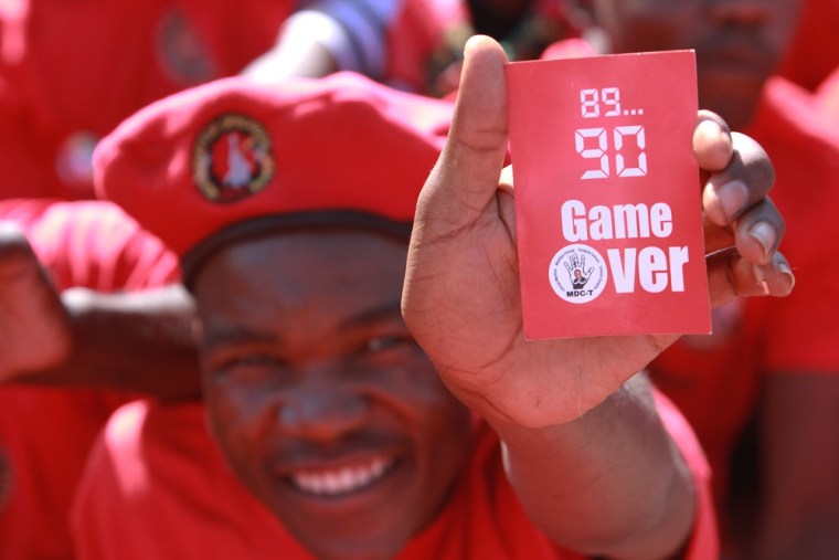 A Movement For Democratic Change supporter holds up a red card to show his backing for Morgan Tsvangirai.