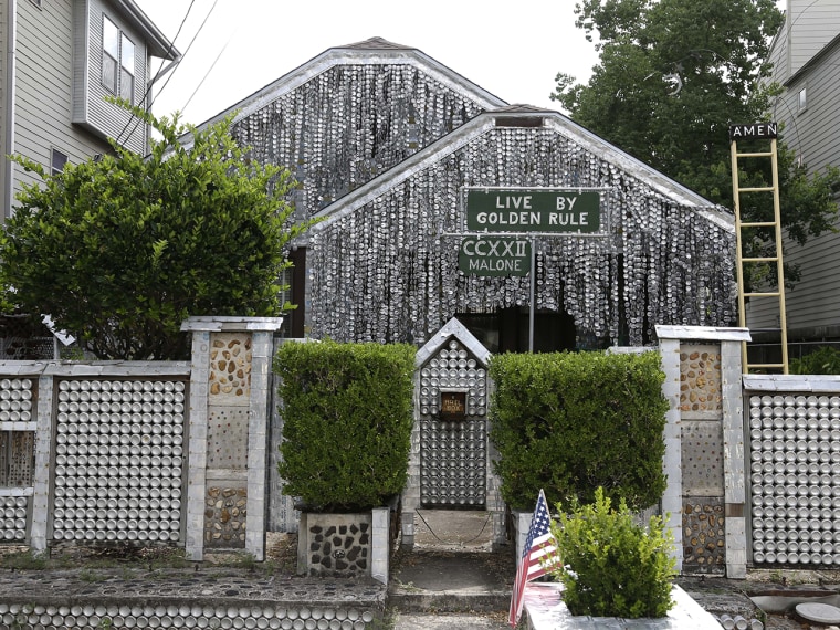 The beer can house, a Houston landmark, sits between newer homes Wednesday, July 10, 2013, in Houston. Former owner John Milkovisch covered the outsid...