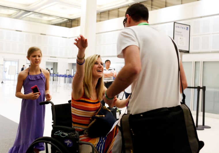 Boston bombing survivor Rebekah Gregory, center, greets her boyfriend Pete DiMartino after he arrives from Rochester, N.Y., on July 24, 2013, in Houston at Bush Intercontinental Airport. Gregory's mother Tina Gregory, left, and sister Allie Gregory, 11, stand behind Rebekah.