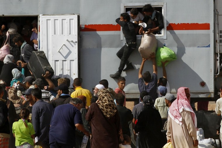 Syrians refugees try to enter a truck which will transport them back to their homeland at the Al-Zaatri refugee camp in the Jordanian city of Mafraq, near the border with Syria, on July 30.