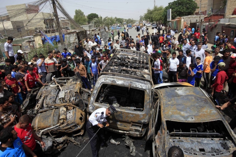 People gather at the scene of a car bomb attack in the Sadr City neighborhood of Baghdad, Iraq, May 16.