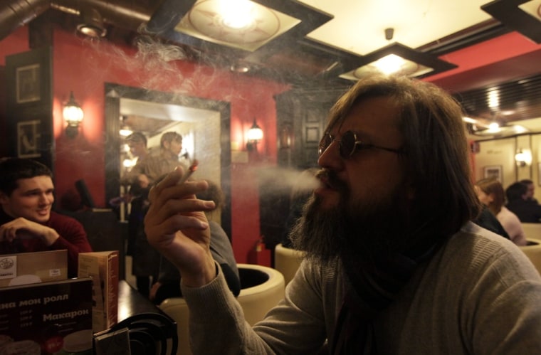 A man smokes a cigarette at a cafe in central Krasnoyarsk in Siberia January 24, 2013. Russian President Vladimir Putin has signed a law that will ban smoking in most public places and restrict cigarette sales in the world's second-largest tobacco market after China as of June 1.