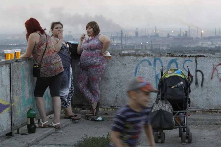 Local residents share a smoke during sunset in the Southern Urals city of Magnitogorsk in July 2012.