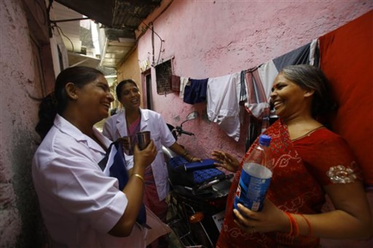Usha Devi, right, who was suffering from cervical cancer, talks with health workers from Tata Memorial Hospital in a slum in Mumbai, India. Devi says a simple vinegar test saved her life.