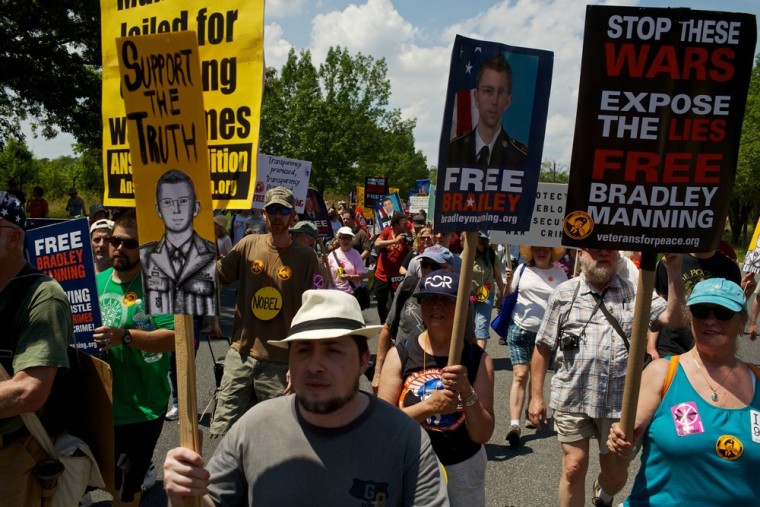 FORT MEADE, MD - JUNE 1: Marchers hold signs at a mass rally in support for PFC Bradley Manning on June 1, 2013 in Fort Meade, Maryland. Manning's court martial is set to begin Monday June 3, 2013. Hundreds of supporters marched in support of Manning for giving classified documents to the anti-secrecy groups WikiLeaks. (Photo by Lexey Swall/Getty Images)