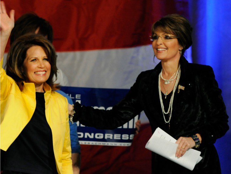 Rep. Michele Bachmann, R-Minn., left, waves to the rally crowd as Sarah Palin looks on before Paliln addressed the crowd in support of Bachmann's re-election on April 7, 2010 in Minneapolis.