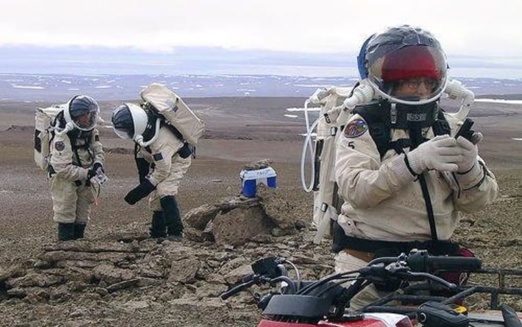 The Mars Society will attempt to conduct a one-year simulated human Mars exploration mission in the Canadian high Arctic at its Flashline Mars Arctic Research Station (FMARS). This scenario depicts crew members checking their equipment during a simulated EVA.