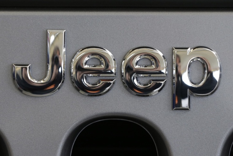 This Feb. 14, 2013 photo shows a Jeep logo on the grill of a Jeep Wrangler at the 2013 Pittsburgh Auto Show in Pittsburgh.