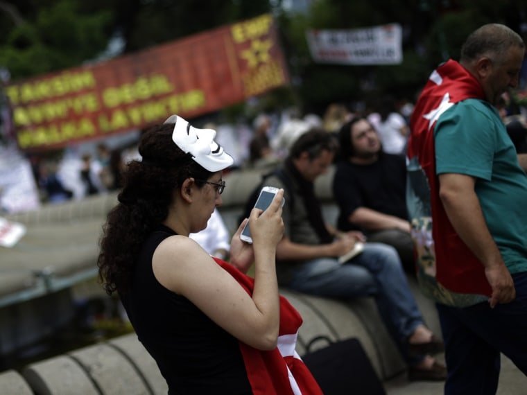 A protester uses her mobile device as she walks at Gezi Park on Taksim Square in Istanbul June 6, 2013. The government has made clear its disapproval ...