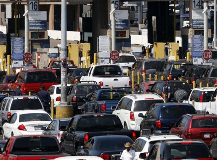 FILE - This Sept. 22, 2009 file shows federal agents mixing into a swarm of automobiles as they do security checks on vehicles waiting to enter the U...