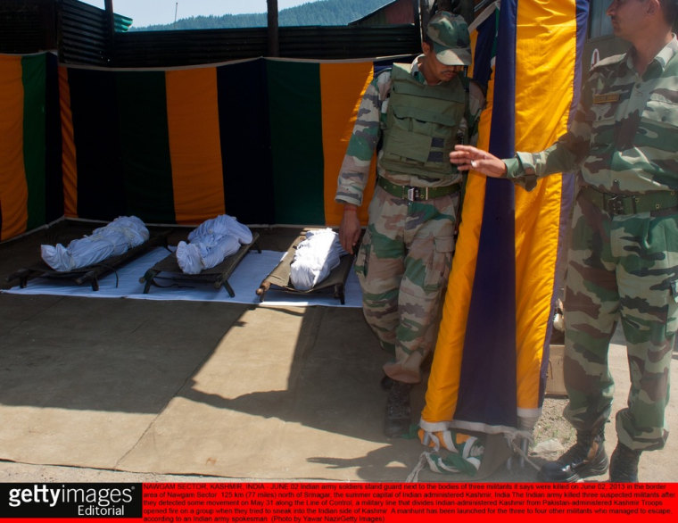 Indian army soldiers stand guard next to the bodies of three militants it says were killed on June 2, 2013 in the border area of Nawgam Sector.