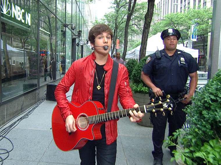 Mahone strolls casually from Studio 1A to the plaza while playing.