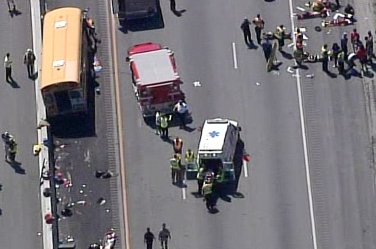 Emergency crews attend to those injured in a school bus crash Tuesday, June 11, in Louisville, Ky.