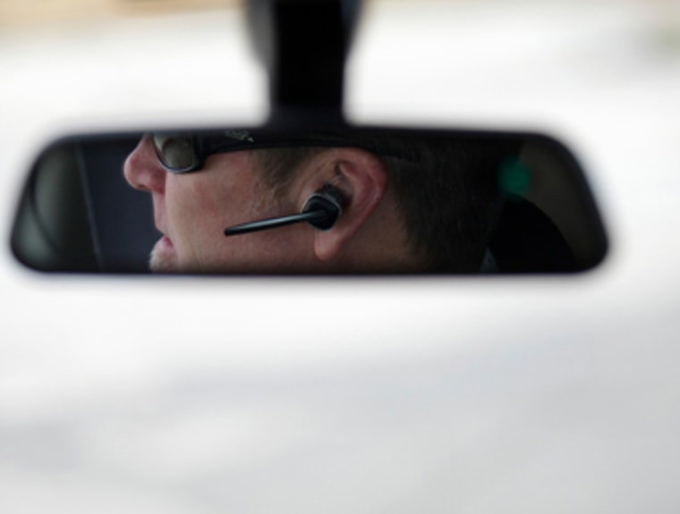 Person driving and talking on phone hands-free.