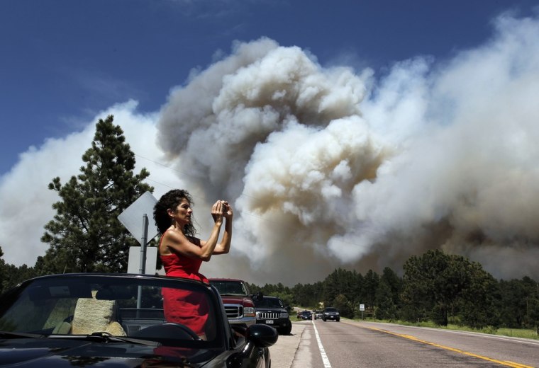 Colorado Springs resident Yolette Baca takes a photo of the wildfire in the Black Forest area north of Colorado Springs, Colo., on June 12, 2013.