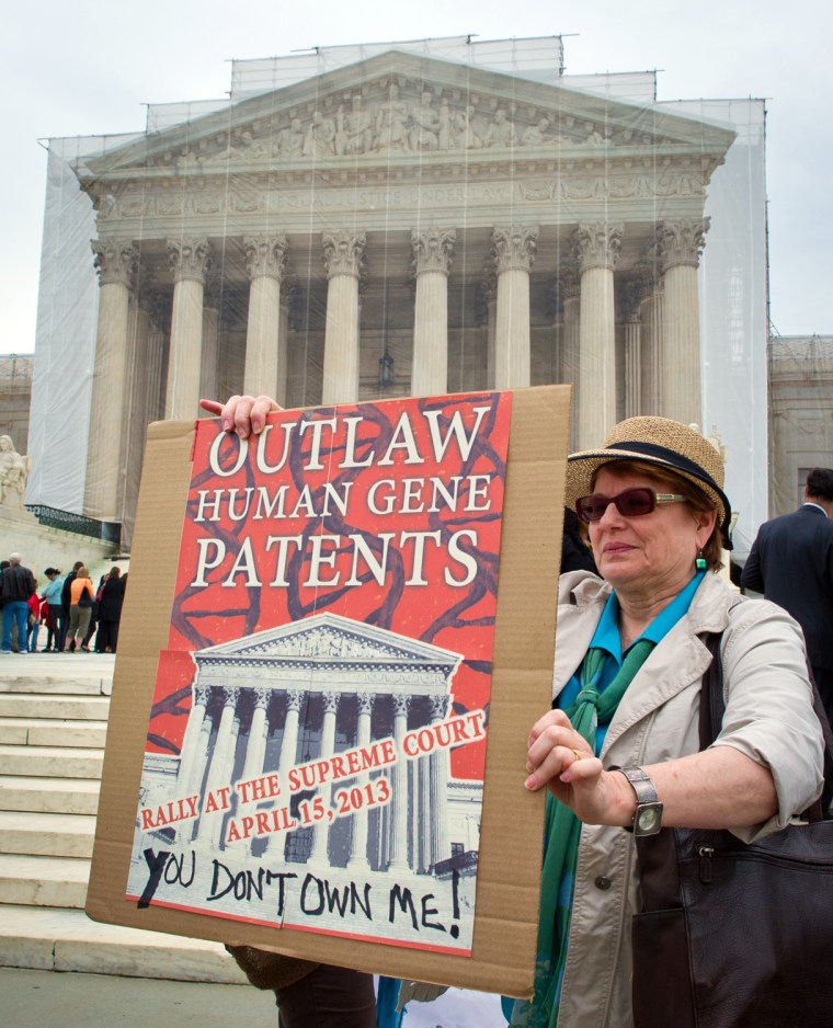 A woman holds a banner demanding a ban on human-gene patents during a protest outside the Supreme Court in April.