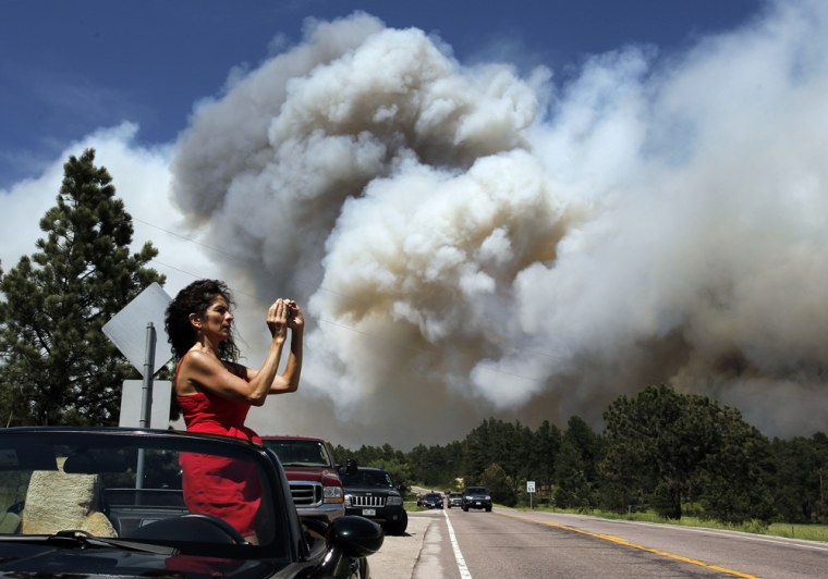 Colorado Springs resident Yolette Baca takes a photo of the wildfire in the Black Forest area north of Colorado Springs, Colo., on Wednesday, June 12,...