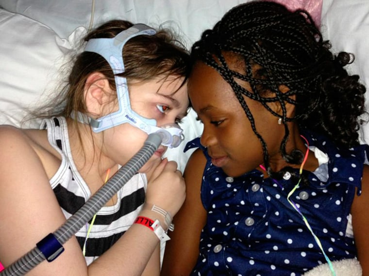 Sarah Murnaghan, left, lies in her hospital bed next to adopted sister Ella on the 100th day of her stay in Children's Hospital of Philadelphia.