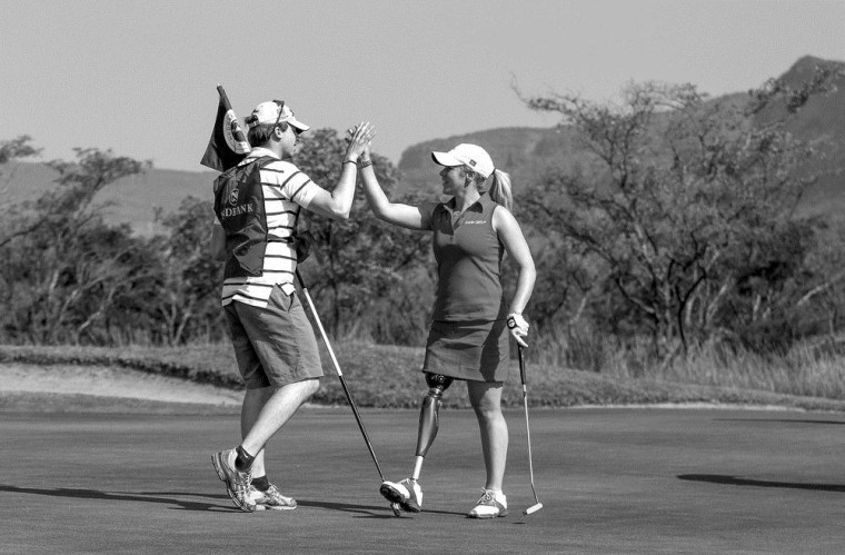 Single leg amputee Caroline Larsson from Sweden high fives her caddie after sinking a long putt during the Nedbank Disabled Golf Open at Legends Golf course in Limpopo, South Africa on May 14.
