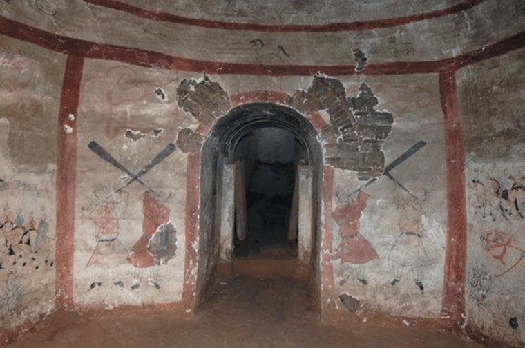 Four men blow into long horns at the entranceway into a 1,500-year-old tomb chamber, located on the south wall. The mural tomb likely held a military commander and his wife in what is now Shuozhou City, China.