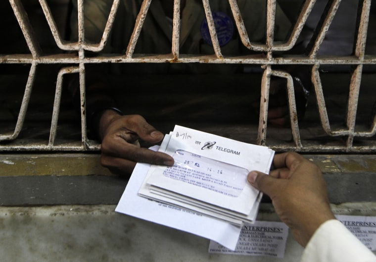 An Indian staff member, foreground, of central telegraph office dispatches telegrams in Mumbai, India, Friday, June 14, 2013. The state-run telecom fi...