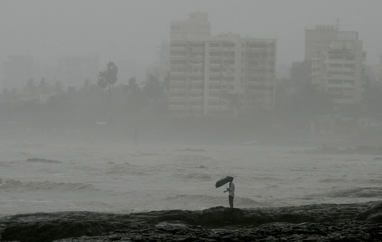 An Indian man stands by the sea front during heavy rain showers in Mumbai on June 18, 2013. The monsoon, which India's farming sector depends on, covers the subcontinent from June to September, usually bringing some flooding. But the heavy rains arrived early this year, catching many by surprise. The country has received 68 percent more rain than normal for this time of year, data from the India Meteorological Department shows.