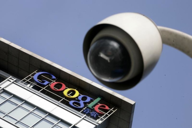 The Google logo is seen on the top of its China headquarters building behind a road surveillance camera in Beijing January 26, 2010. REUTERS/Jason Lee