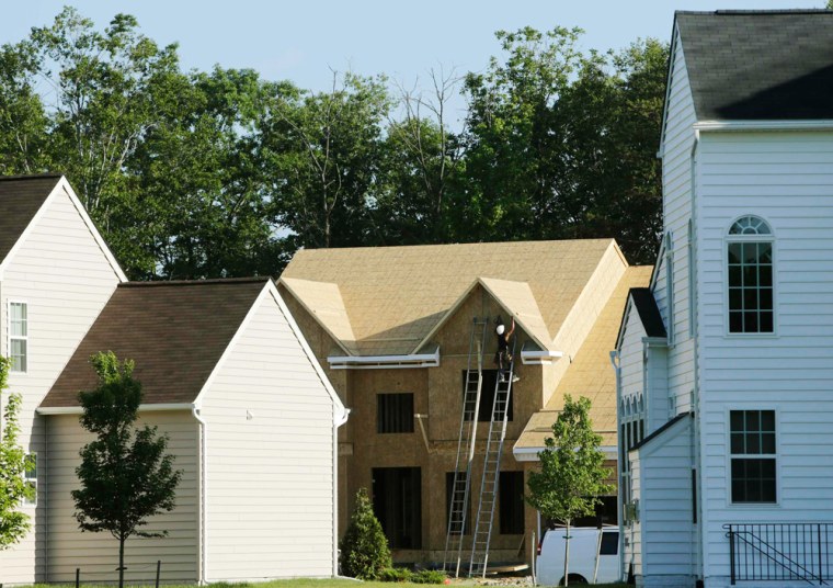 A carpenter (C) works on a housing site at Mid-Atlantic Builders'