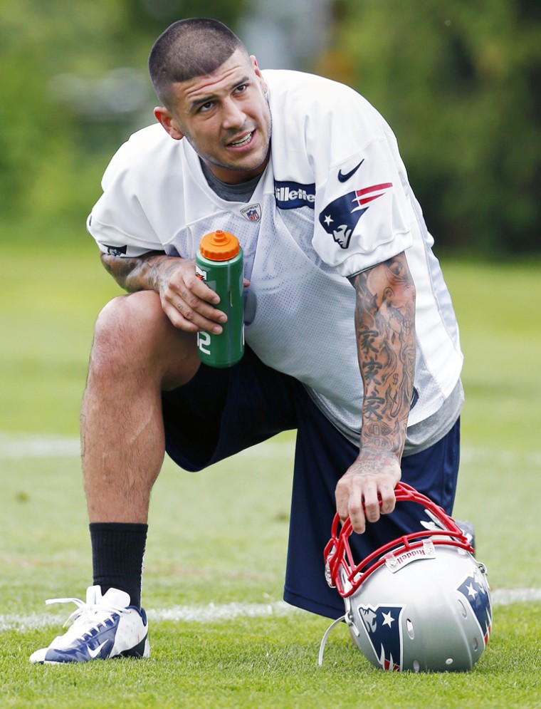 The New England Patriots' Aaron Hernandez kneels on the field during practice in May.