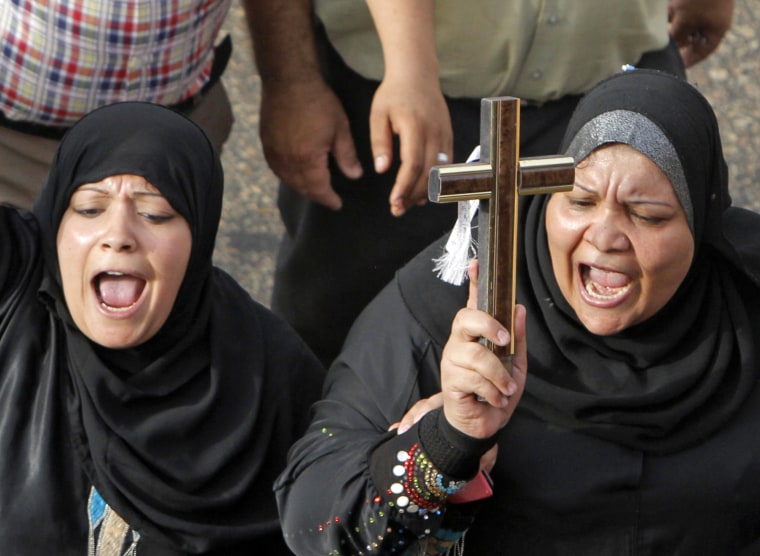 Egyptian Muslim women hold a cross in support of Christians during a memorial march in Cairo for Christians who were killed during deadly clashes with Muslims in April.
