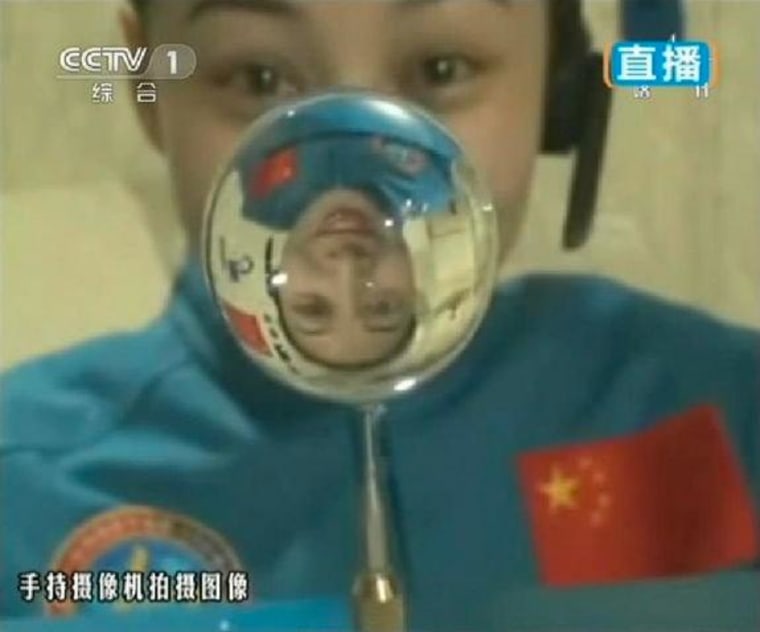 This screengrab shows astronaut Wang Yaping, one of the three crew members of Shenzhou-10 spacecraft, making a water ball in space during a lecture to students on Earth from aboard China's space module.
