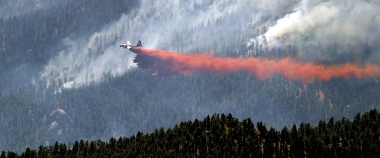 A slurry bomber drops a stream of fire retardant on the Lime Gulch wildfire near Pine, Colo., on Thursday, June 20, 2013. Hot, windy conditions across Colorado left firefighters battling multiple wildfires, while residents in broad swaths of the state were warned about smoke in what has become the state's most damaging fire season in history. (AP Photo/Ed Andrieski)