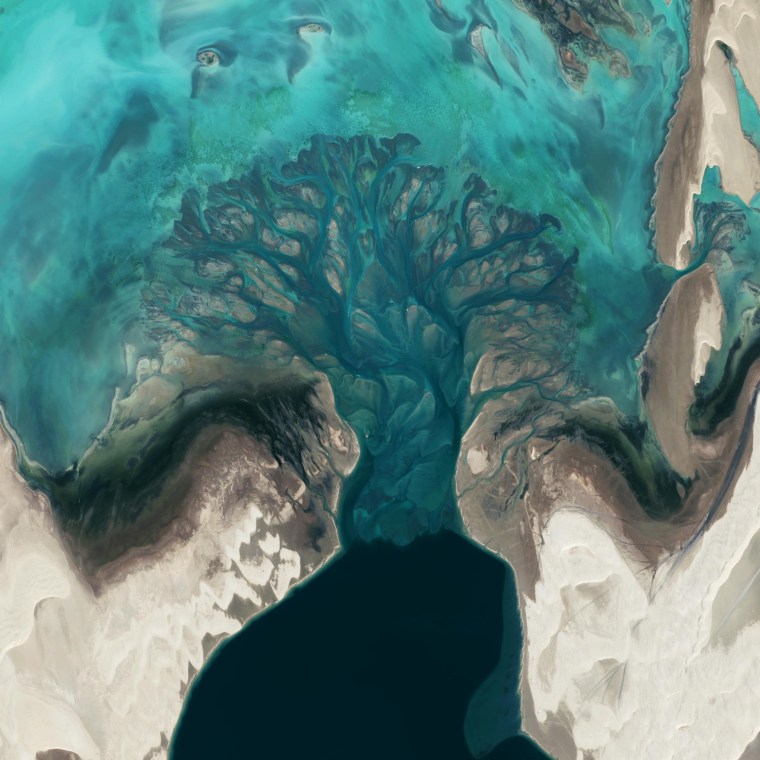 The blue water and patterns of sediment in Khor al-Adaid, or Inland Sea, create a lovely effect when viewed from space by the GeoEye 1 satellite.