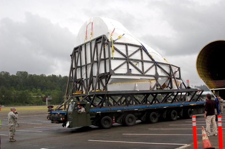 The cargo compartment for the Full Fuselage Trainer, wrapped in protective plastic, has been taken out of the Super Guppy for a short ride on the Tunner transporter to its new home in the Museum of Flight's Charles Simonyi Space Gallery.