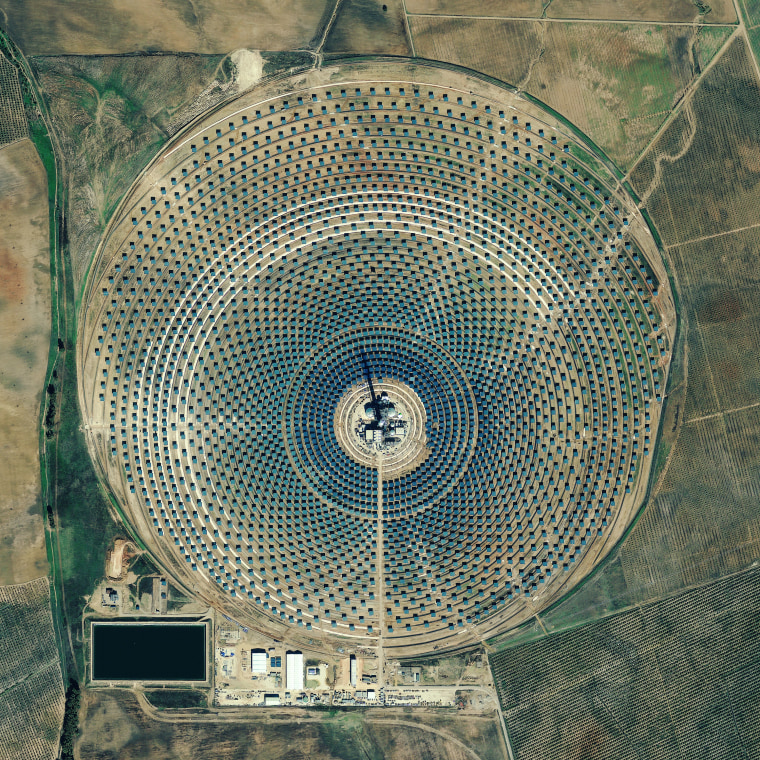 A picture taken by the GeoEye 1 satellte on Nov. 4, 2010, shows the Gemasolar power-generating array in Seville, Spain. At the center of the array is a 40-story-high concrete tower, ringed by 2,650 mirrors. The mirrors focus sunlight on the tower, which stores the heat and converts it to energy.